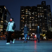 People enter a bus station in Beijing during evening rush hour last month. | REUTERS