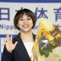 Mai Murakami poses for photos after her retirement news conference in Yokohama on Monday. | KYODO