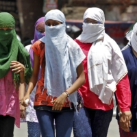 People cover their faces to protect themselves from the heat in Allahabad, India, during a heat wave in 2015. | REUTERS 