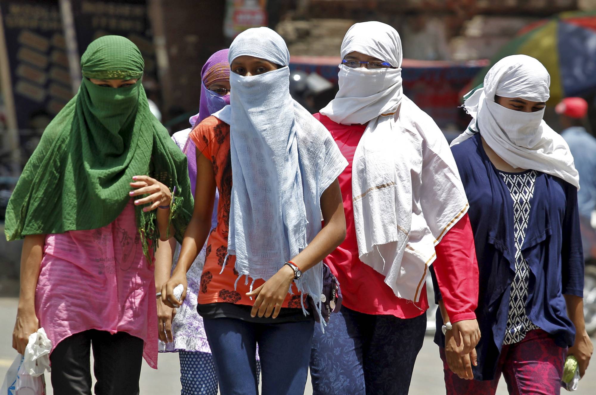 People cover their faces to protect themselves from the heat in Allahabad, India, during a heat wave in 2015. | Reuters 