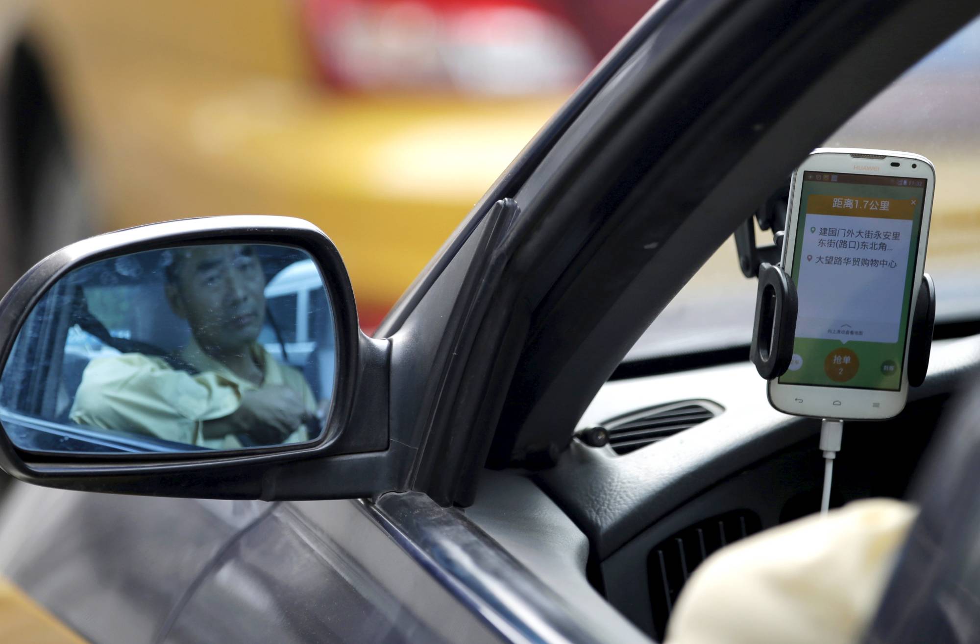 A taxi driver uses the Didi Chuxing car-hailing app in Beijing. | Reuters 