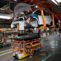 An automated guided vehicle carrying a battery pack moves under a partially assembled Chevrolet Bolt at a factory in Lake Orion, Michigan. | REUTERS 
