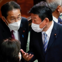 Prime Minister Fumio Kishida talks to Liberal Democratic Party Secretary-General Toshimitsu Motegi during a parliamentary session at the Lower House in Tokyo on Wednesday. | REUTERS