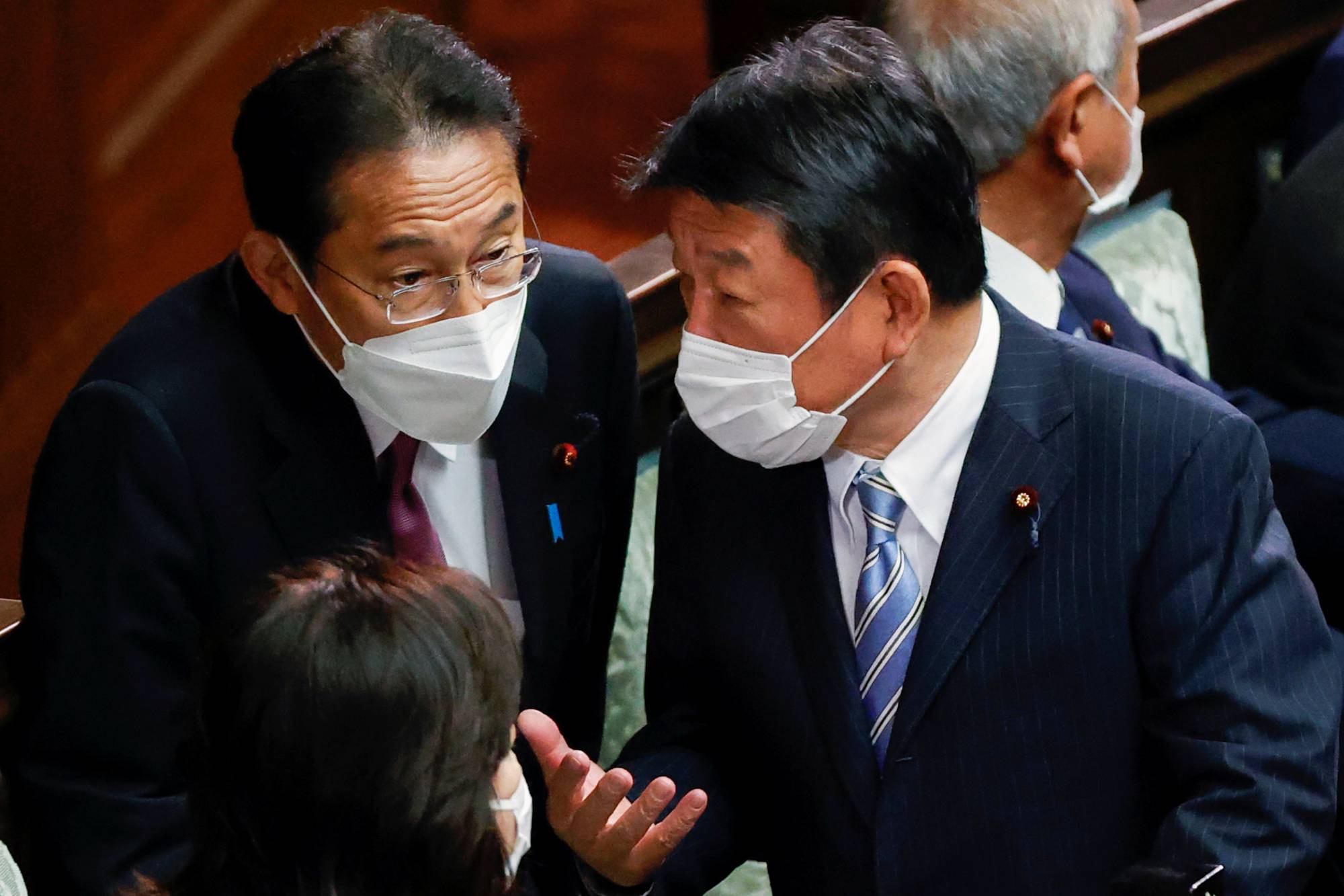 Prime Minister Fumio Kishida talks to Liberal Democratic Party Secretary-General Toshimitsu Motegi during a parliamentary session at the Lower House in Tokyo on Wednesday. | REUTERS