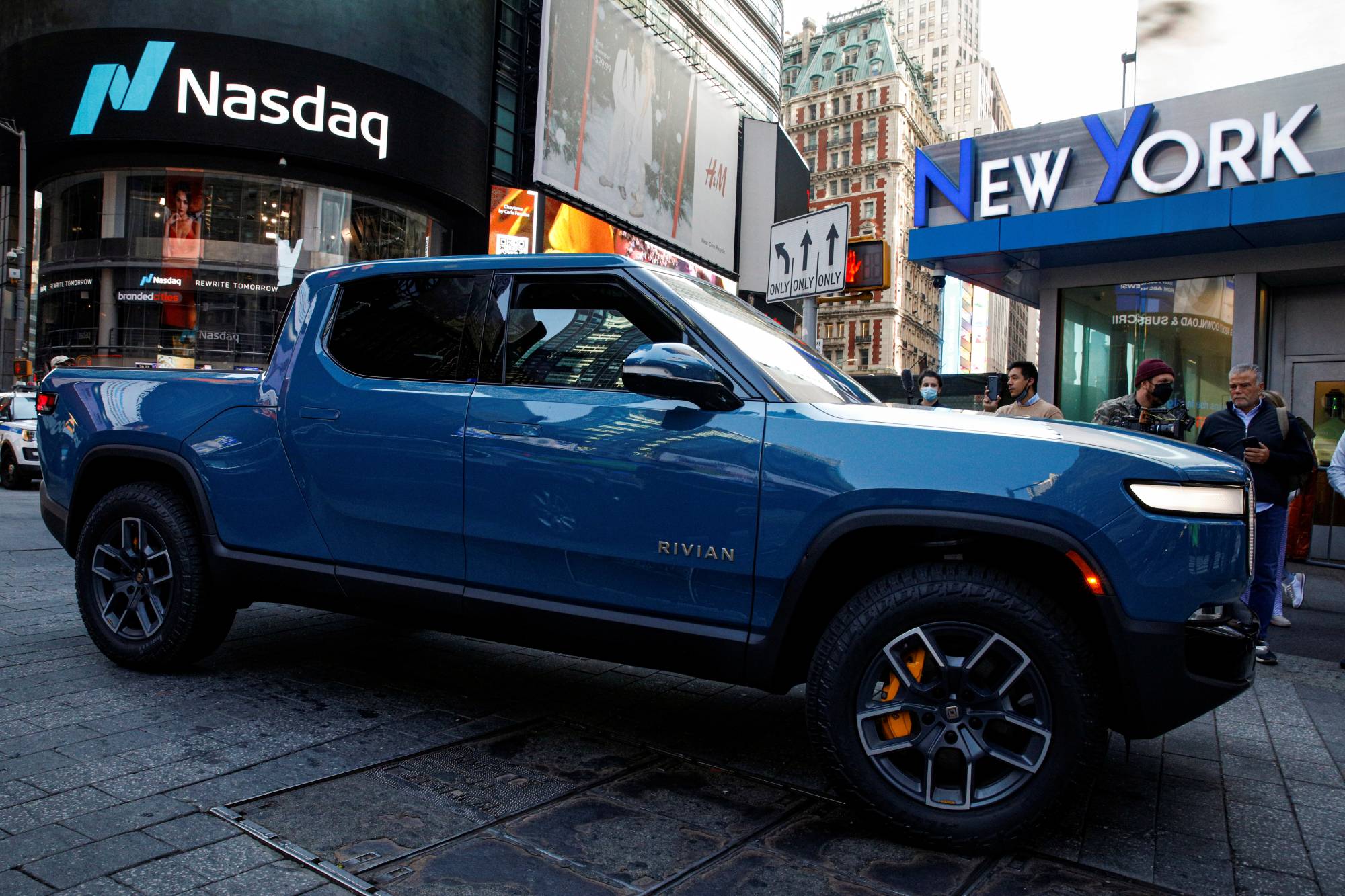A Rivian R1T pickup is driven outside the Nasdaq Market site during the company’s IPO in Times Square in New York on Wednesday.  | REUTERS 