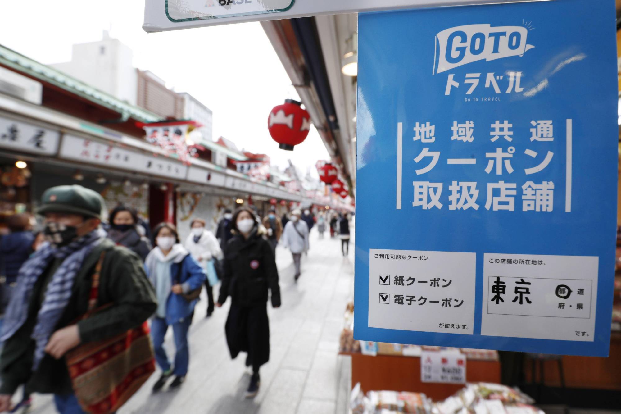 A sign promoting the government’s Go To Travel subsidy program is displayed in a shopping street in Tokyo’s Asakusa district in December 2020. | KYODO