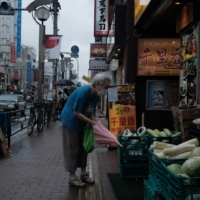 A customer shops at a food stall in Tokyo\'s Shinjuku Ward in August. | BLOOMBERG