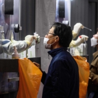 A man and woman undergo PCR tests at a COVID-19 testing center in Seoul on Nov. 3. | AFP-JIJI