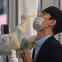 A man undergoes a PCR test at a COVID-19 testing center in Seoul on Nov. 3. | AFP-JIJI
