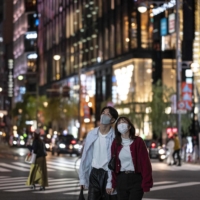 People walk on a street at night in Tokyo on Nov. 3. | AFP-JIJI