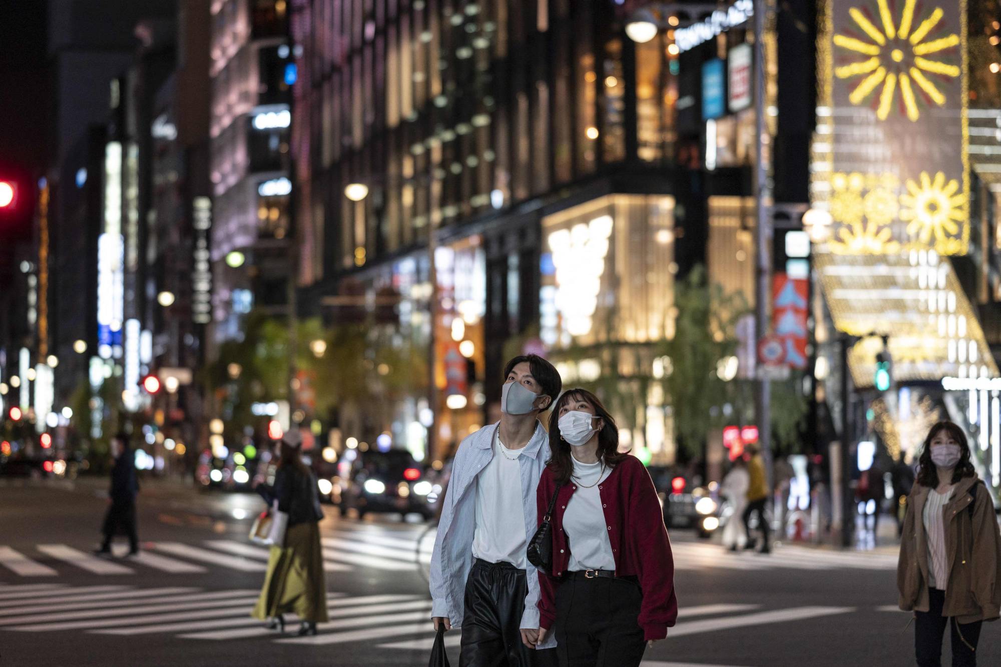 People walk on a street at night in Tokyo on Nov. 3. | AFP-JIJI