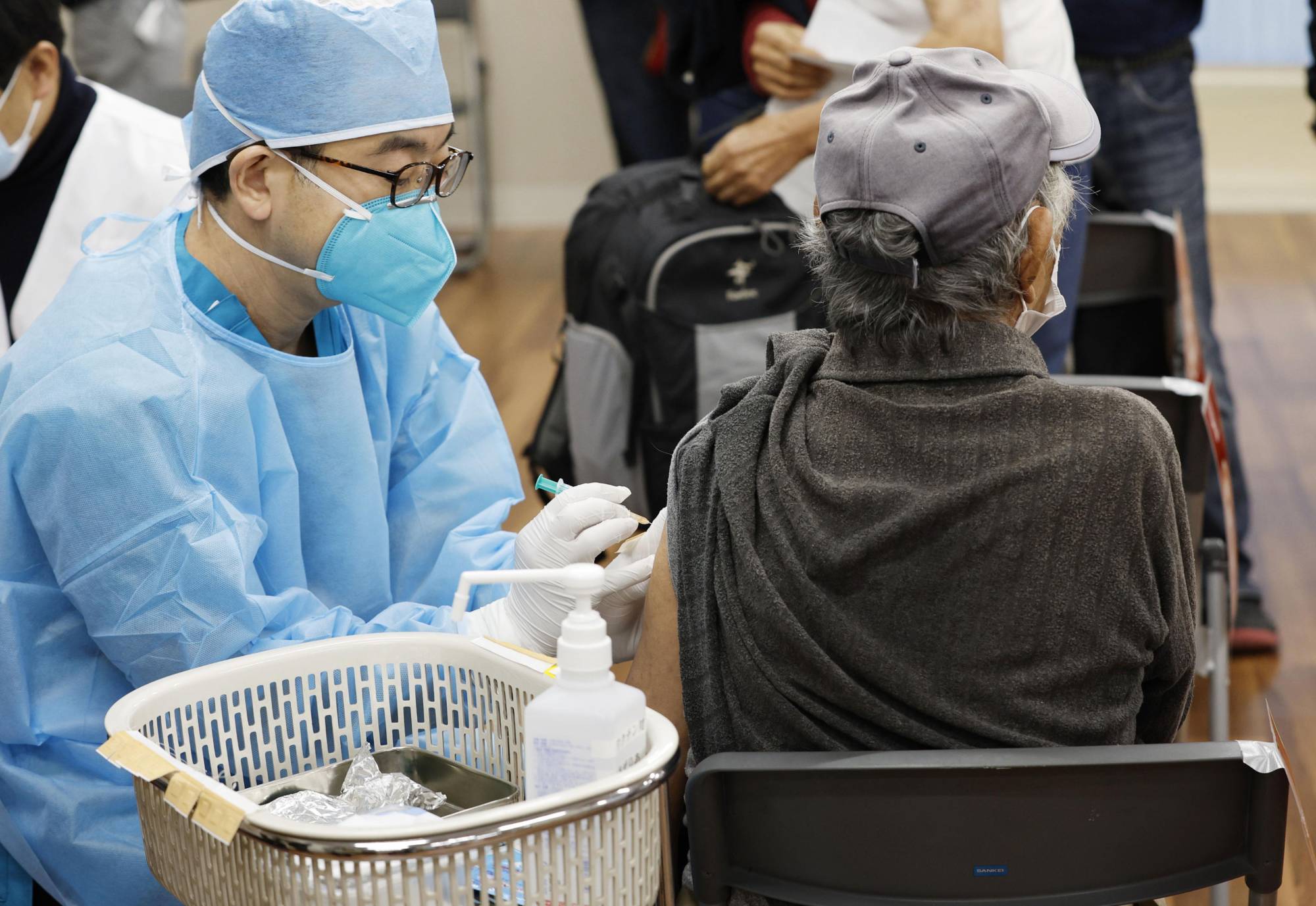 Homeless people receive COVID-19 vaccine shots in Tokyo's Toshima Ward on Oct. 30. | KYODO
