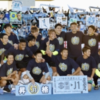Jubilo players take a commemorative photo with fans after clinching their return to the J1 League in Mito, Ibaraki Prefecture, on Sunday. | KYODO