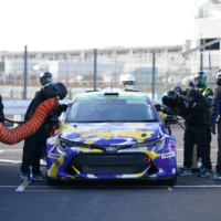 Pit crew members refuel Toyota Corp.\'s Corolla Sport H2 Concept vehicle, equipped with a hydrogen-powered engine, during a practice session at Okayama International Circuit in Mimasaka, Okayama Prefecture, on Saturday. | BLOOMBERG