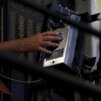 A death row inmate uses a phone from his cell at San Quentin State Prison in San Quentin, California in 2015. The Verus AI-scanning system sold by California-based LEO Technologies uses Amazon speech-to-text technology to search phone calls for keywords flagged by police. | REUTERS
