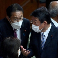 Prime Minister Fumio Kishida (left) speaks with LDP Secretary-General Toshimitsu Motegi during a Lower House plenary session on Nov. 10. | AFP-JIJI