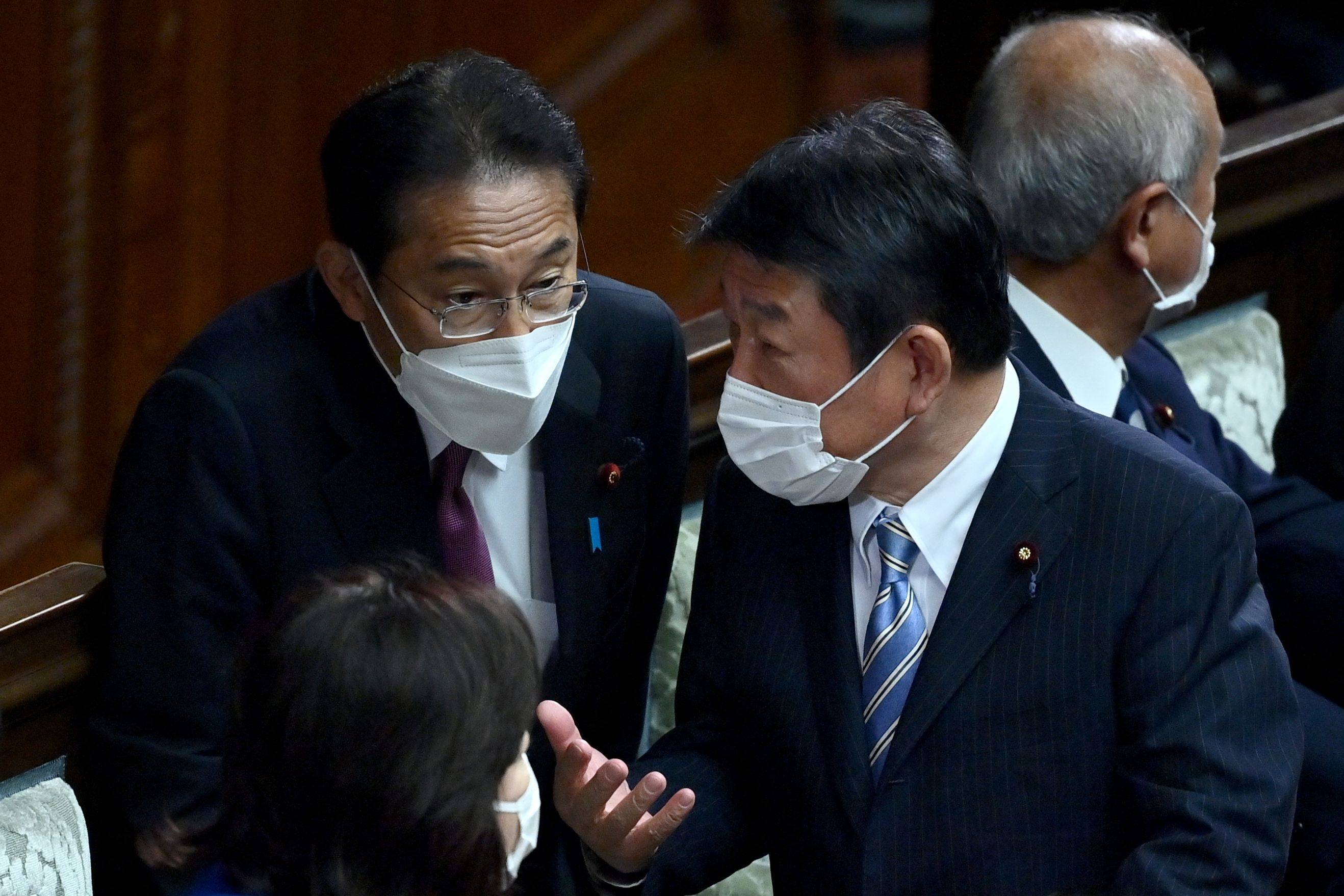 Prime Minister Fumio Kishida (left) speaks with LDP Secretary-General Toshimitsu Motegi during a Lower House plenary session on Nov. 10. | AFP-JIJI