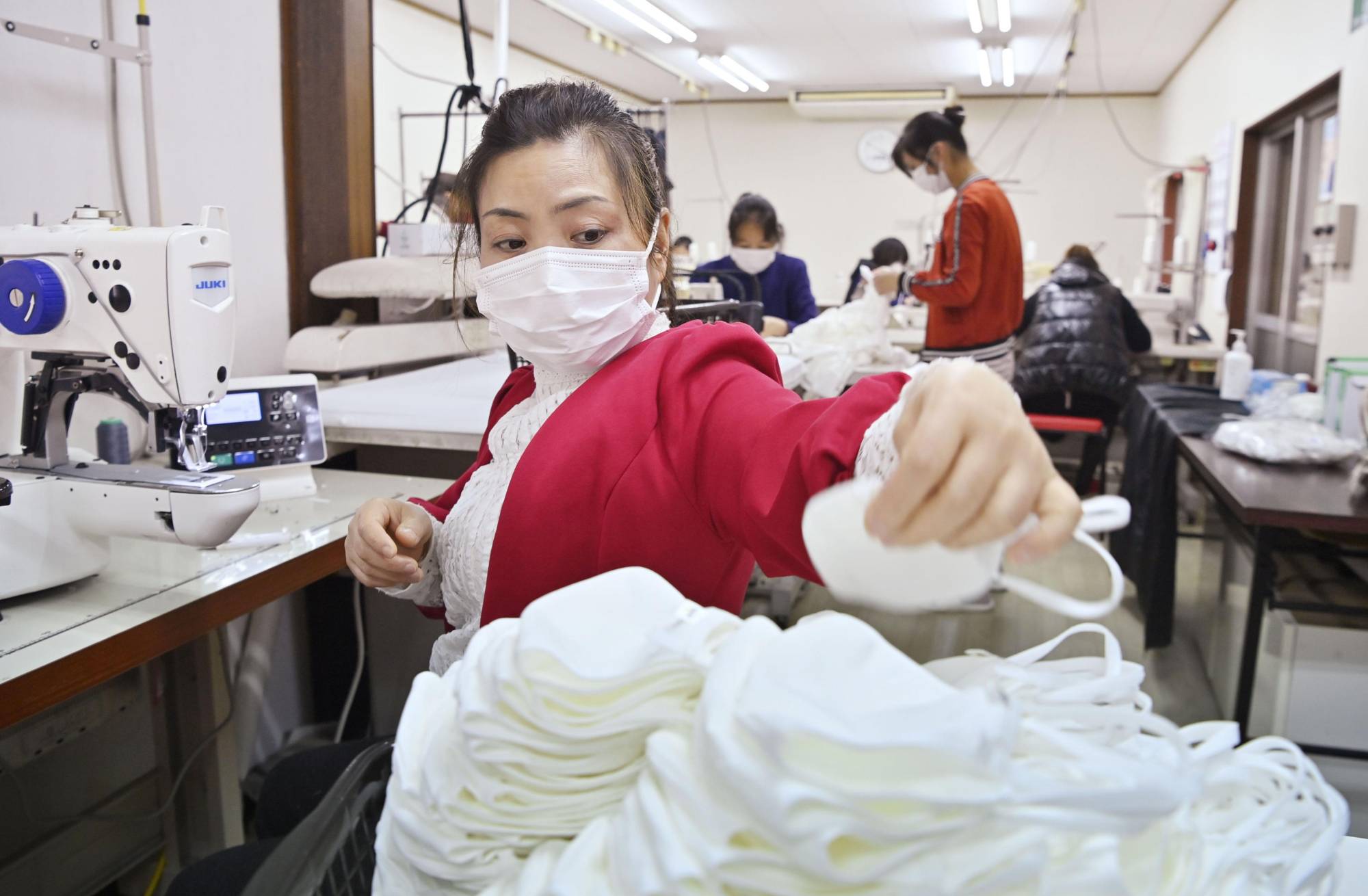A foreign technical trainee makes cloth face masks for a garment maker in Gifu Prefecture. | KYODO