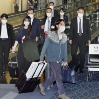 Kei Komuro and his wife, former Princess Mako, leave Haneda Airport for New York on Sunday. | KYODO