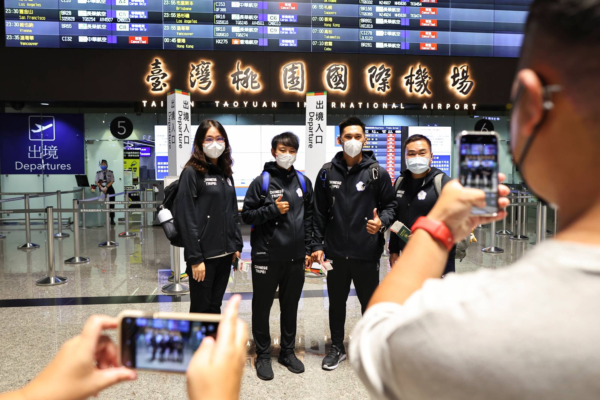Li Sin-rong (second from the left), 23, a Taiwanese luger, poses for group photos with her teammates at the airport in Taoyuan, Taiwan on Oct. 17 before traveling abroad for training and qualifying competitions for the 2022 Beijing Winter Olympics. | REUTERS