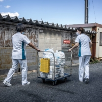 Health care workers at the Daisen Rehabilitation Hospital in Houki, Tottori Prefecture, collect used adult diapers to be recycled into pellets on Oct. 7. Waste from adult diapers is growing by tens of thousands of tons a year in Japan.  | JAMES WHITLOW DELANO/THE NEW YORK TIMES
