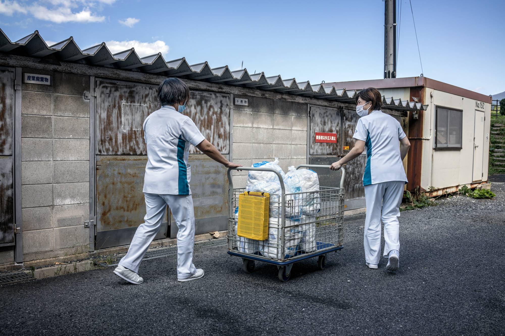 Health care workers at the Daisen Rehabilitation Hospital in Houki, Tottori Prefecture, collect used adult diapers to be recycled into pellets on Oct. 7. Waste from adult diapers is growing by tens of thousands of tons a year in Japan.  | JAMES WHITLOW DELANO/THE NEW YORK TIMES
