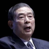 Yoshitaka Kitao, chief executive officer of SBI Holdings Inc., speaks at a fintech summit in Tokyo in March. | BLOOMBERG