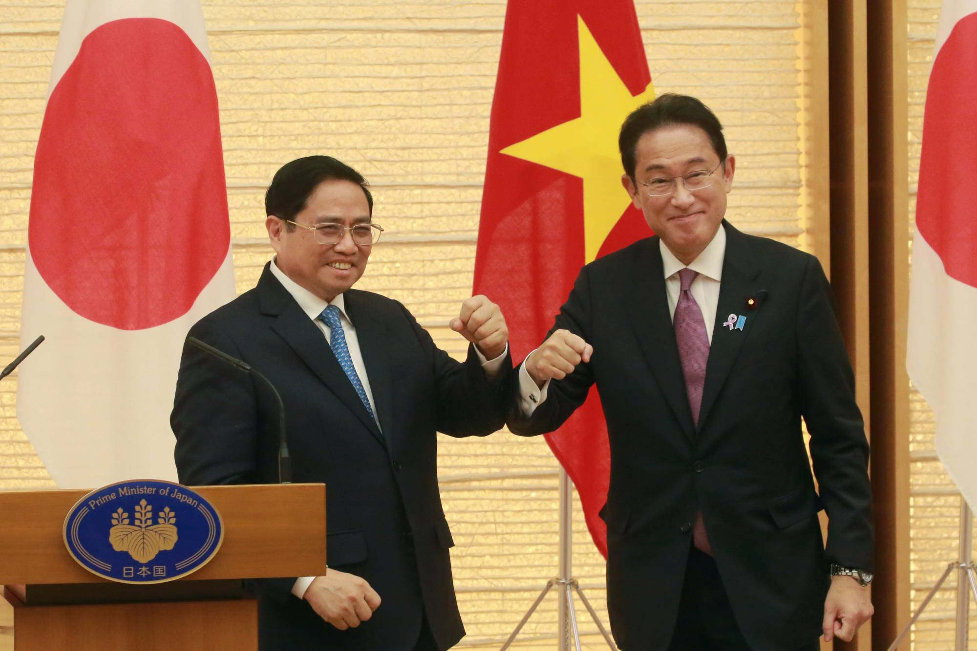 Prime Minister Fumio Kishida and his visiting Vietnamese counterpart, Pham Minh Chinh, pose for a photo following a news conference in Tokyo on Wednesday. | POOL / VIA BLOOMBERG