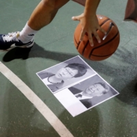 A protester dribbles a basketball over pictures of China\'s President Xi Jinping and Hong Kong Chief Executive Carrie Lam during a gathering in support of the Houston Rockets general manager Daryl Morey, who backed the pro-democracy movement in a tweet, in Hong Kong in October 2019.  | REUTERS