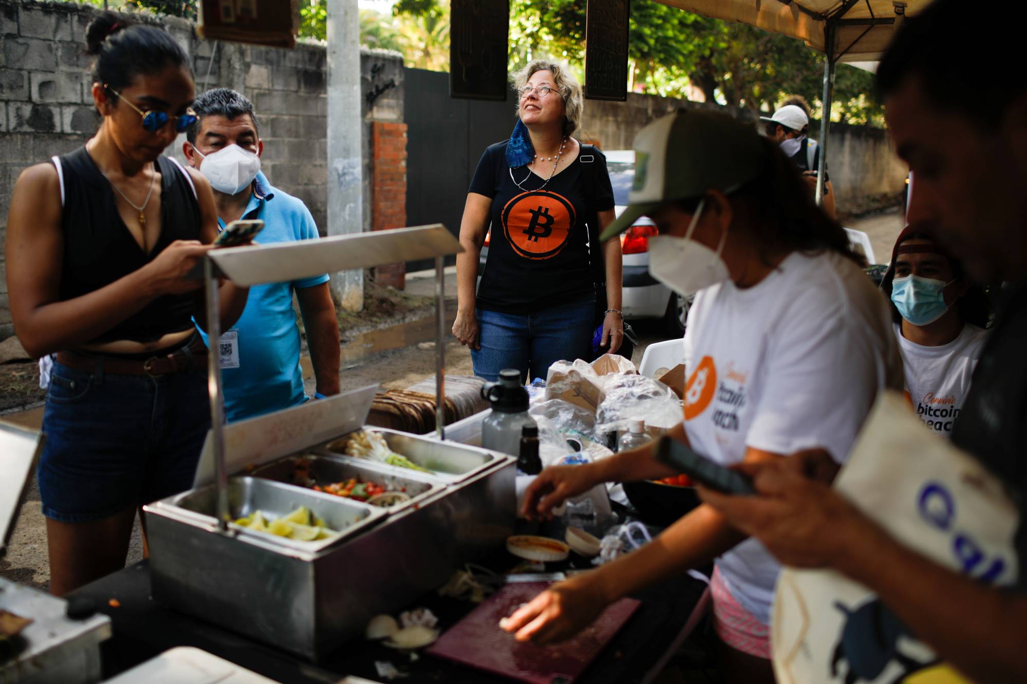 People buy traditional food from a local Bitcoin merchant at El Zonte Beach in Chiltiupan, El Salvador, on Nov. 18. | Reuters 