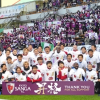Kyoto Sanga players and coaches celebrate their promotion to the J. League\'s first division in Chiba on Sunday. | KYODO