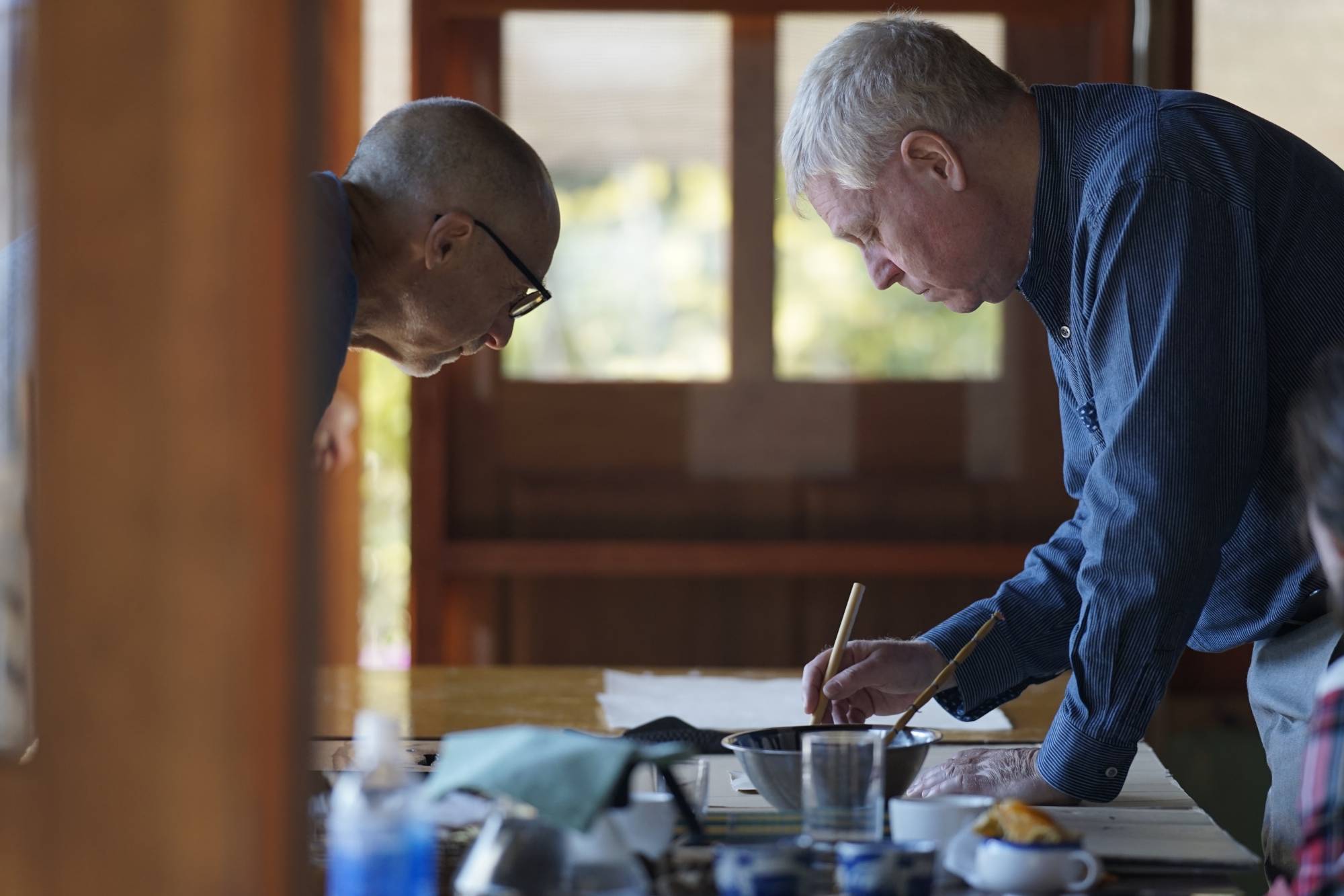Author Alex Kerr practices calligraphy at Washi Studio Kamikoya in Kochi Prefecture. | CHIARA TERZUOLO