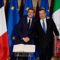French President Emmanuel Macron (left) and Italian Prime Minister Mario Draghi shake hands after signing the Quirinal Treaty between Italy and France in Rome on Friday. | POOL / VIA AFP-JIJI)