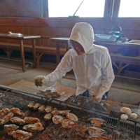 An ama diver prepares a range of seafood, including oysters, at Osatsu Kamado ama hut. | STEPHEN MANSFIELD
