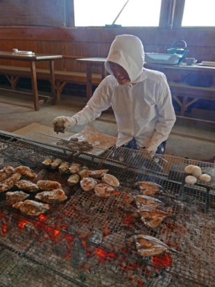 An ama diver prepares a range of seafood, including oysters, at Osatsu Kamado ama hut. | STEPHEN MANSFIELD 