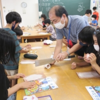Art teacher Yasuji Iba teaches students how to make a pen stand with paper clay at Kibukawa Elementary School in Koka, Shiga Prefecture, in October. | CHUNICHI SHIMBUN
