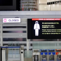 A notice about COVID-19 safety measures at a departure hall of Narita Airport in Chiba Prefecture on Tuesday.  | REUTERS