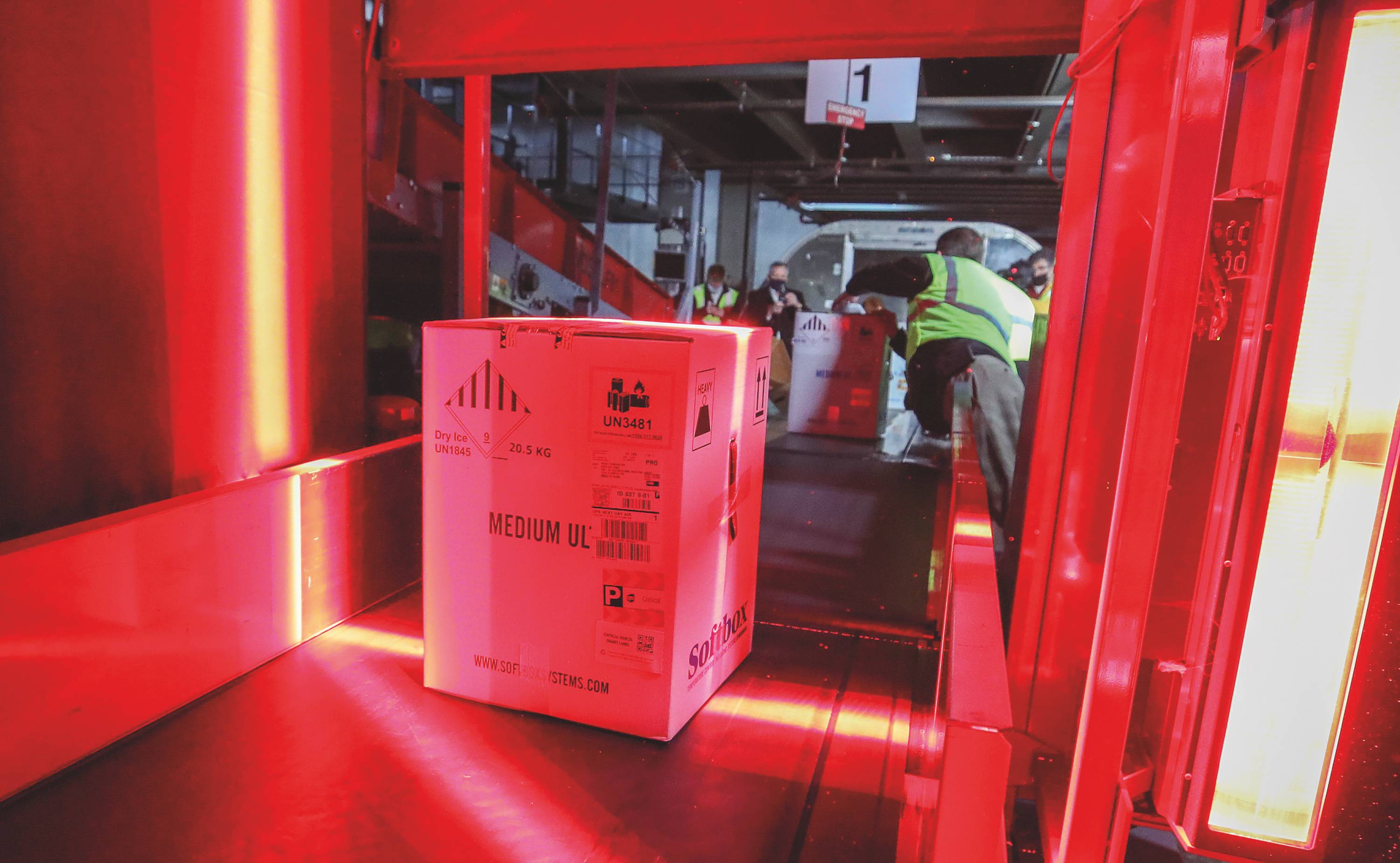 Boxes containing the first shipments of the Pfizer COVID-19 vaccine are unloaded from air shipping containers and scanned at UPS Worldport in Louisville, Kentucky, on Dec. 13, 2020. | Michael Clevenger / Pool / Getty Images