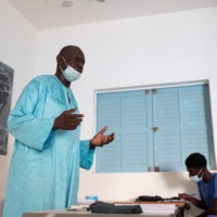 Mbaye Ndiaye, a science teacher, speaks to a class about his inoculation experience in Dakar, Senegal, in September.  | RICCI SHRYOCK / THE NEW YORK TIMES