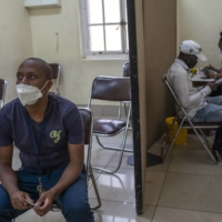 A man waits to receive a dose of COVID-19 vaccine in Johannesburg on Tuesday. Vaccines are finally available in many African countries, but some people there, as well as in South Asia, are wary of taking them. | JOAO SILVA / THE NEW YORK TIMES