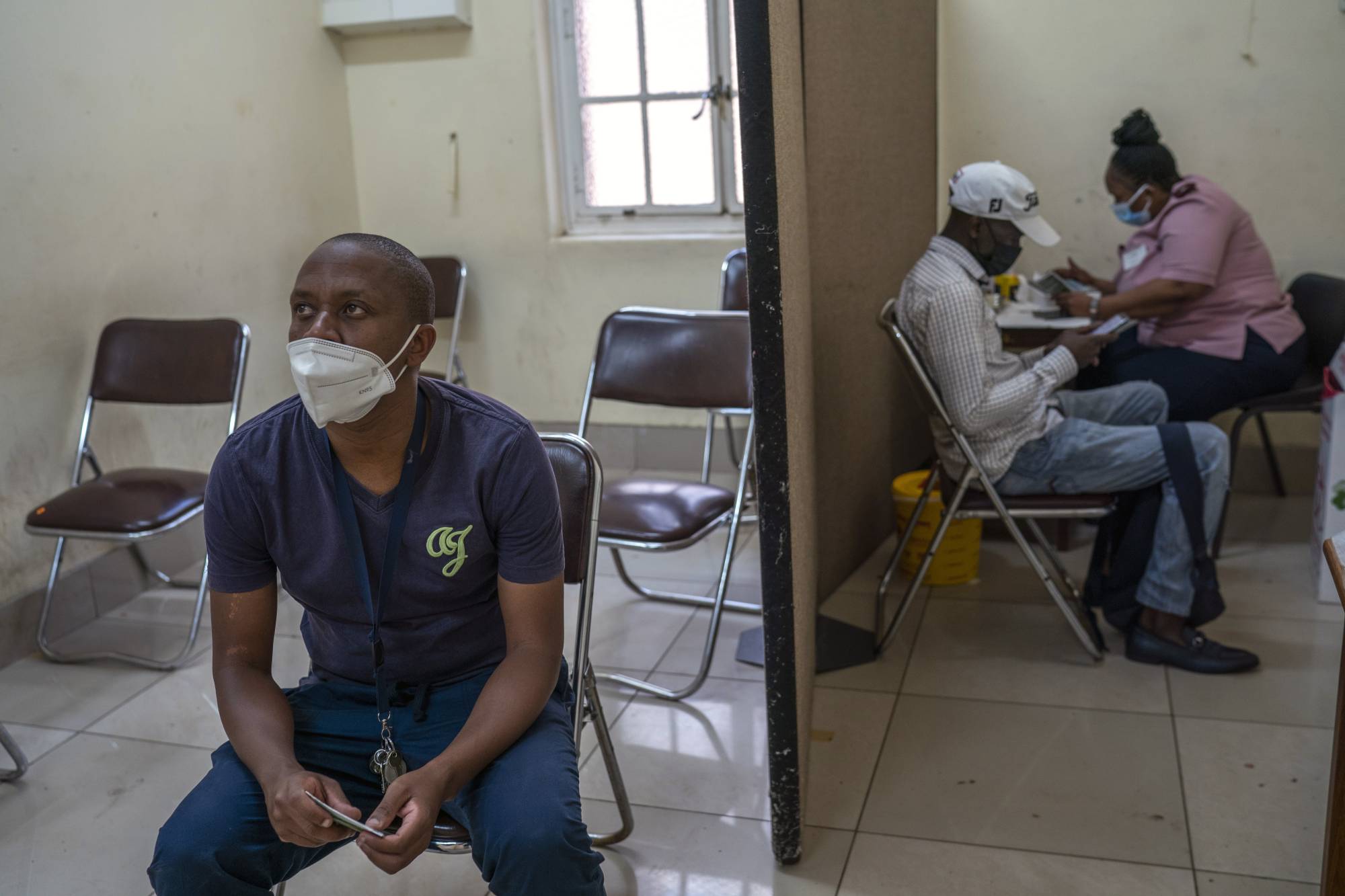 A man waits to receive a dose of COVID-19 vaccine in Johannesburg on Tuesday. Vaccines are finally available in many African countries, but some people there, as well as in South Asia, are wary of taking them. | JOAO SILVA / THE NEW YORK TIMES