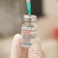 A health care worker fills up a syringe with a dose of Moderna\'s COVID-19 vaccine for a booster shot, in Zurich on Nov. 17. | REUTERS