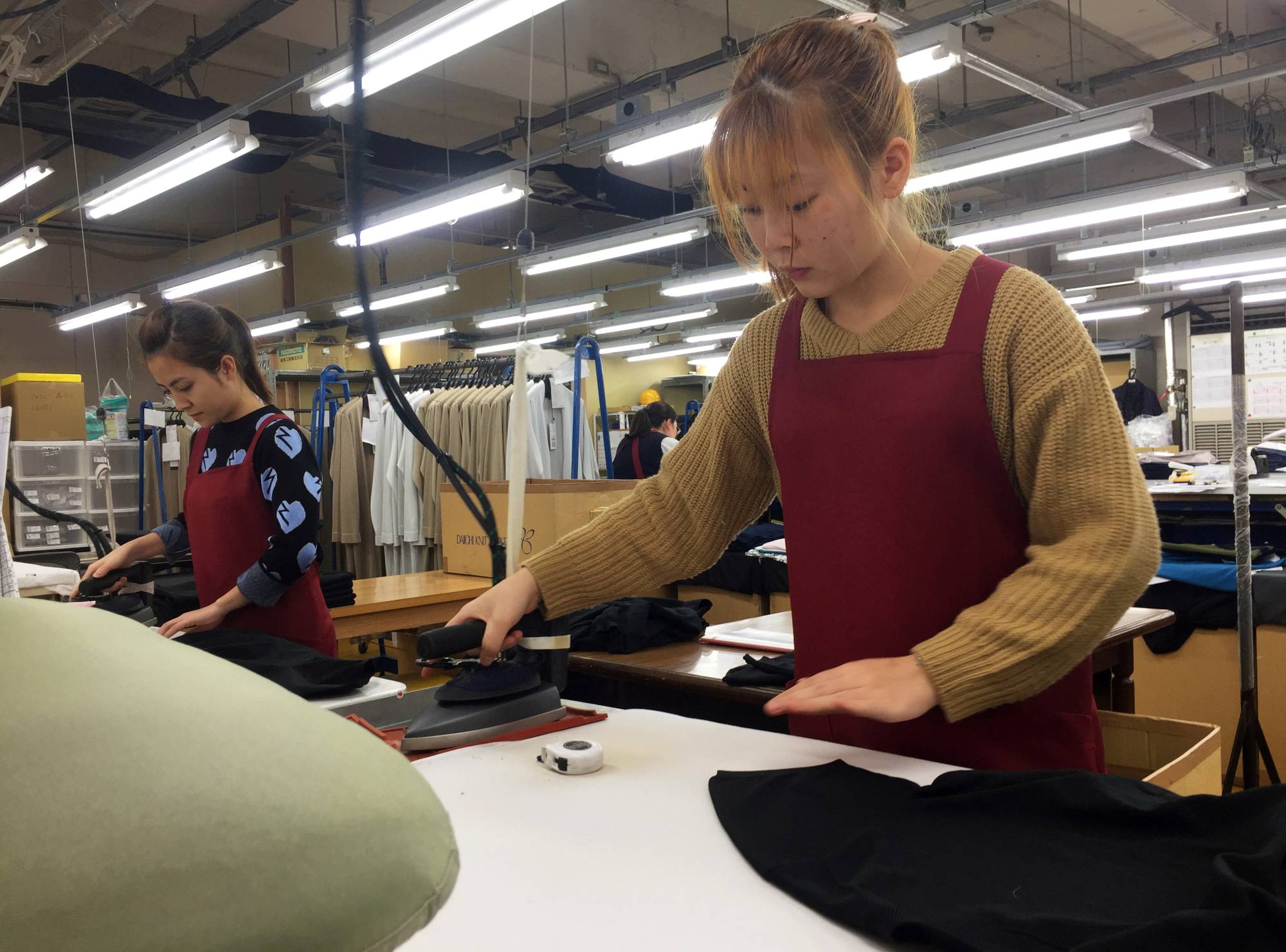 Technical trainees from Vietnam work at a knitwear factory in Mitsuke in 2019. Businesses in Japan have struggled to bring in new recruits from overseas since the country's borders were closed in response to COVID-19 in early 2020.  | REUTERS