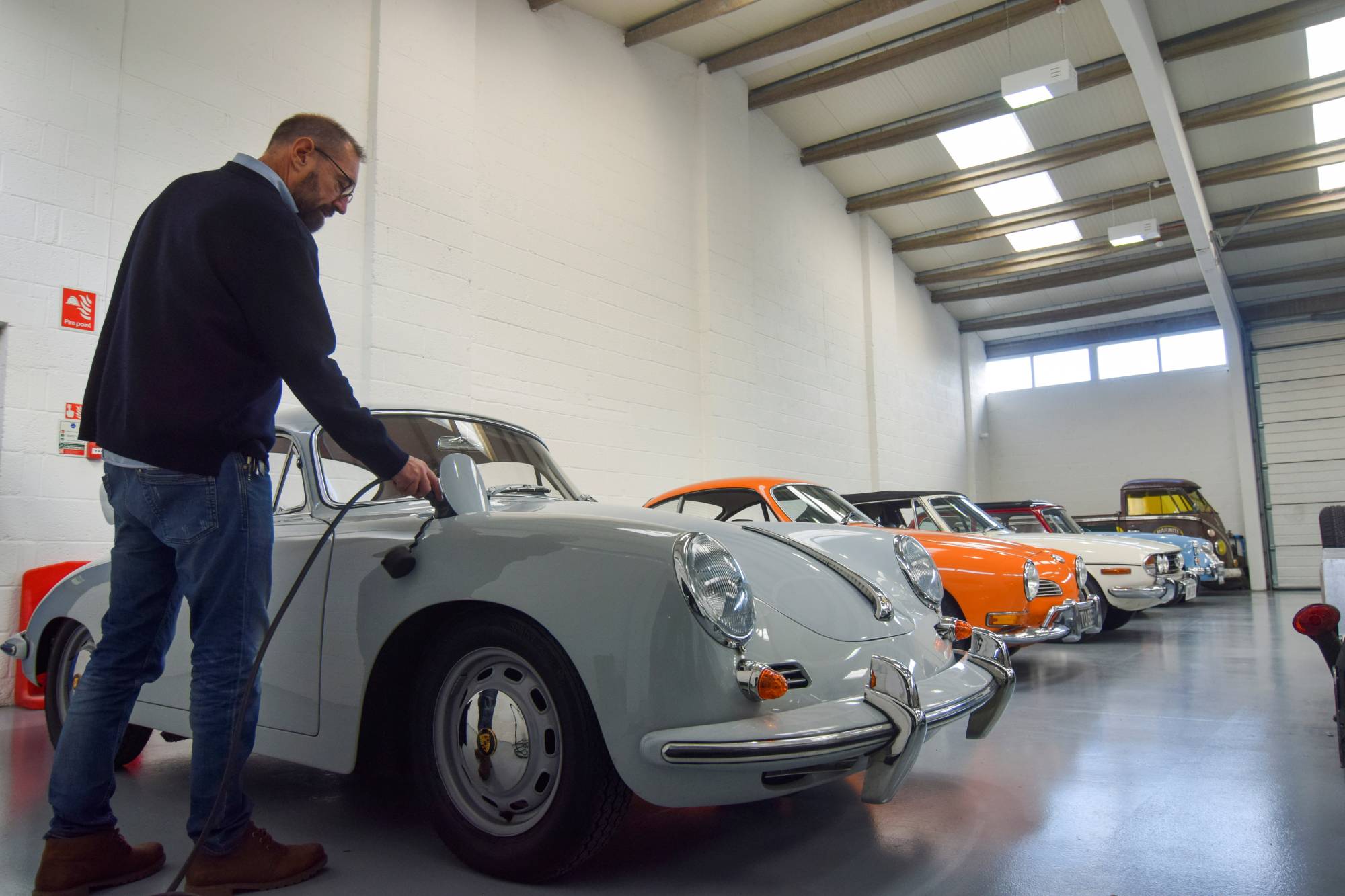 Steve Drummond, co-founder of Electrogenic, which converts classic combustion engine cars to electric, plugs in a converted Porsche in Kidlington, England, on Nov. 9.  | Reuters