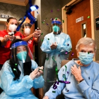 Patients and health care workers at a nursing care facility in West Hartford, Connecticut, celebrate after the administration of the site\'\'s first COVID-19 vaccine dose in December 2020. | POOL VIA REUTERS