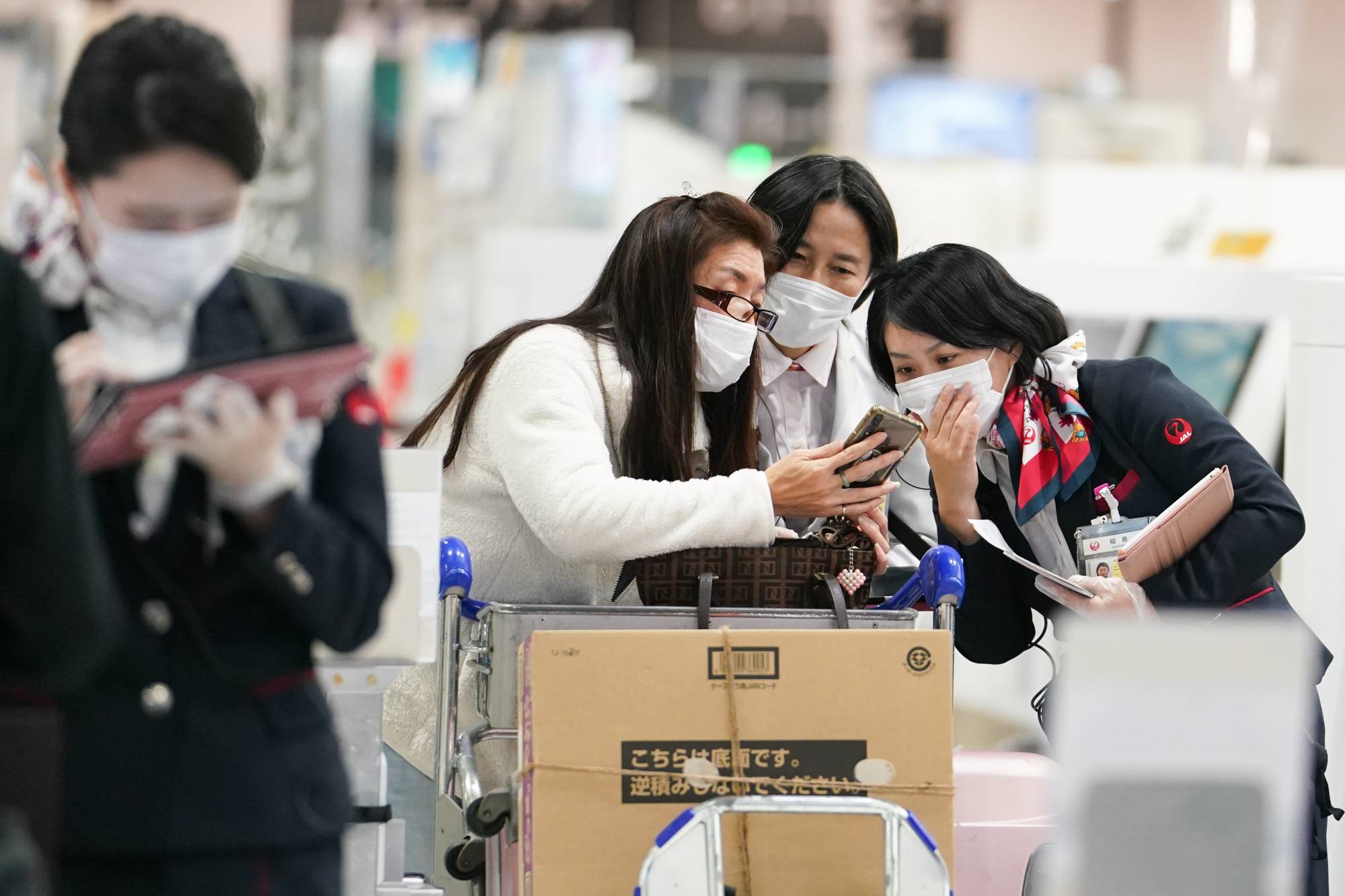 An employee assists travelers at Narita Airport in Chiba Prefecture on Nov. 30. | Bloomberg