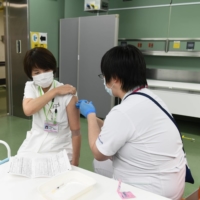 A nurse receives a booster shot of the Pfizer-BioNTech COVID-19 vaccine at Chiba University Hospital on Dec. 1. | BLOOMBERG