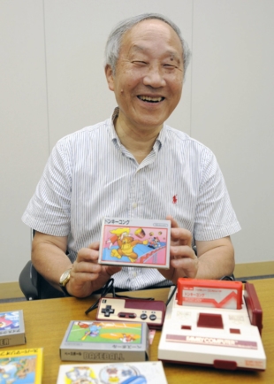 Masayuki Uemura, who developed Nintendo Co.'s Famicom, or NES, game console, holds a Donkey Kong game during an interview in Kyoto in July 2013. | KYODO