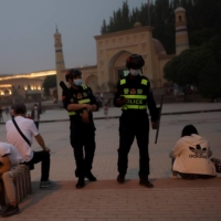 Police officers patrol the square in front of the Id Kah Mosque in Kashgar, Xinjiang Uyghur Autonomous Region, China, in May. | REUTERS