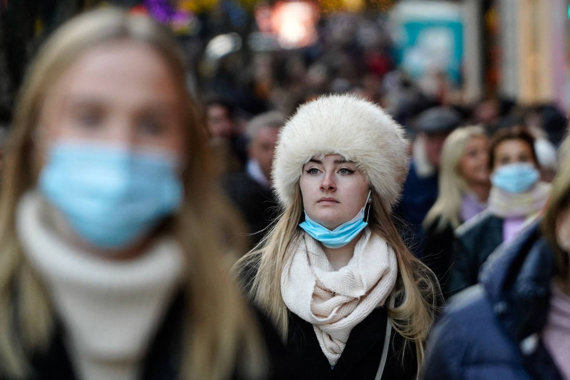 Shoppers, some wearing face masks to combat the spread of the coronavirus, walk along Oxford Street in central London on Friday. | AFP-JIJI